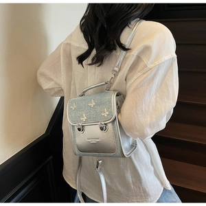 Detail of silver mini backpack with 3D metal butterfly ornaments and sequin flap decoration