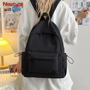 Vista dettagliata di uno zaino in nylon nero con tasca frontale zip e tasca laterale a cordoncino
