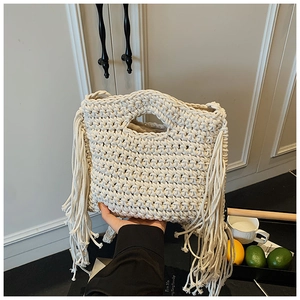 Beigefarbene handgestrickte Tragetasche mit langen Fransen im trendigen Boho-Urlaubsstil