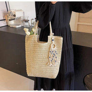 Detail of hand-woven tote bag texture with bohemian evil eye tassel charm decoration