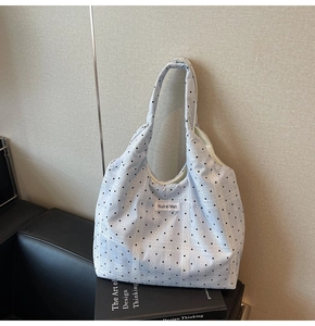 Détail du grand sac cabas en toile bleu clair à pois avec étiquette tissée et design chic