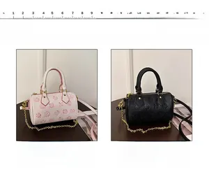 Detailansicht der rosa und schwarzen Eimertaschen mit Cartoon-Prägung und Kettenriemen