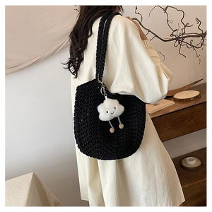 Close-up of black chunky knit tote bag featuring a cute white cloud plush pendant