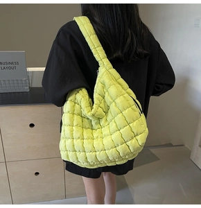 Rear view of a large fluorescent green quilted tote bag with wide shoulder strap