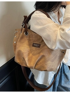 Vintage brown canvas hobo tote bag with wide strap and minimalist leather patch detail
