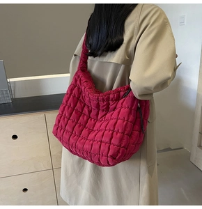 Detailed view of fuchsia quilted tote bag styled with a beige trench coat on a model