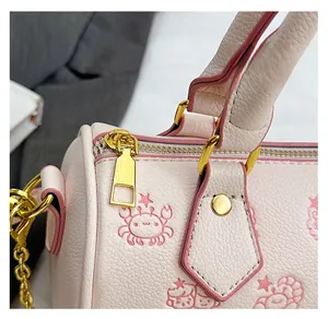 Detail der rosa Boston Bag mit glattem Goldreißverschluss und Cartoon-Krabbenprint