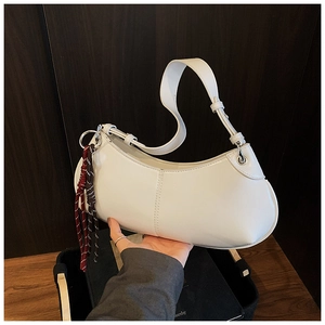 Detail of white half-moon underarm bag with woven rope accent and silver metal buckle