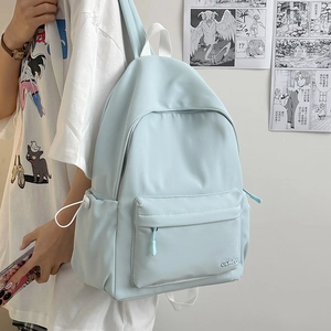 Vista laterale di uno zaino in nylon impermeabile azzurro indossato da un modello