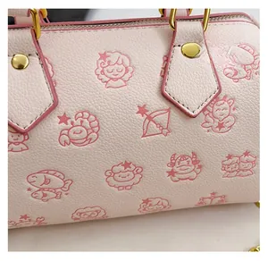 Detail der rosa Boston-Tasche mit Lychee-Muster-Textur und Cartoon-Sternbild-Aufdrucken
