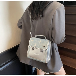 Close-up of a silver glitter crossbody bag featuring elegant butterfly metallic accents