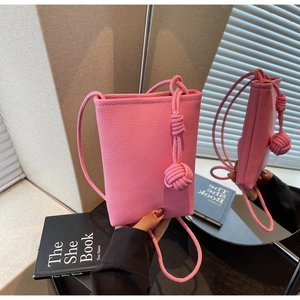 Detail view of pink pebble grain crossbody bag with stylish woven knot decoration