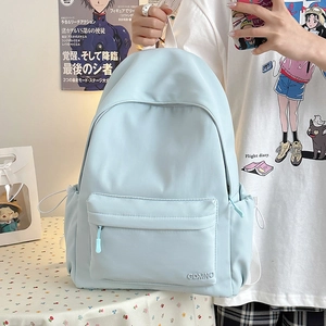 Dettaglio dello zaino in nylon azzurro con ricamo CDMN0 e tasca laterale con coulisse