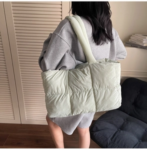 Detail of mint green quilted tote bag featuring a padded puffer texture and large capacity