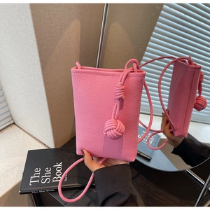 Pink lychee grain leather mini phone bag featuring a stylish knotted shoulder strap detail