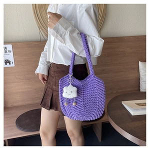 Detail of purple woven tote bag featuring a white cloud plush charm and thick rope texture