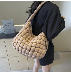 Detailed view of the quilted puff tote bag featuring a textured beige grid pattern