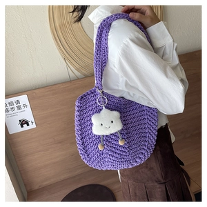 Detail of purple woven tote bag with cute white cloud charm carried by a model