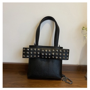 Détail du sac cabas en cuir noir avec clous argentés et bandoulière en chaîne