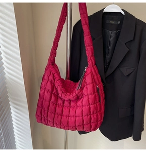Detail of fuchsia quilted cloud bag showing vibrant texture and wide shoulder strap