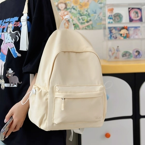 Dettaglio dello zaino in nylon crema con tasca laterale a coulisse e logo ricamato