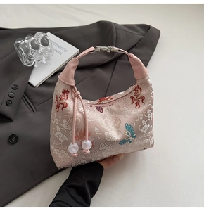 Detailed embroidery of koi and clouds on pink silk satin hobo bag with tassel