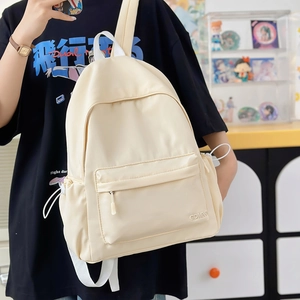 Dettaglio dello zaino in nylon crema con tasche laterali a coulisse e ricami