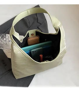 Detail view of large pale green tote bag interior showing capacity for phone and wallet