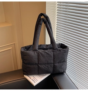 Close-up of black quilted puffer tote bag with large capacity and stylish square design