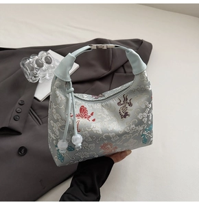 Detailed embroidery on light blue silk dumpling bag with vintage cloud and fish patterns