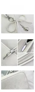 Close-up of white snake pattern leather texture with pearl charm and metal zipper details