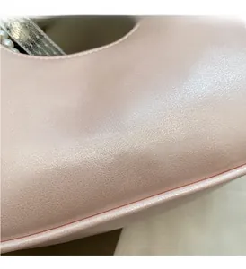 Detail der rosa Kunstlederstruktur mit YNGE & VIER-Logo und Perlen-Spitzen-Akzenten