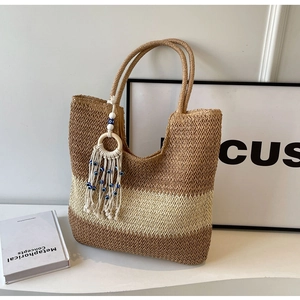 Detail of hand-woven tote bag texture with evil eye tassel and decorative stripes