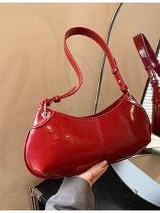Glossy red patent leather crescent shoulder bag with adjustable strap and silver hardware