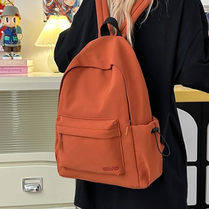 Dettaglio dello zaino trendy in nylon arancione con scomparti spaziosi e tasca frontale