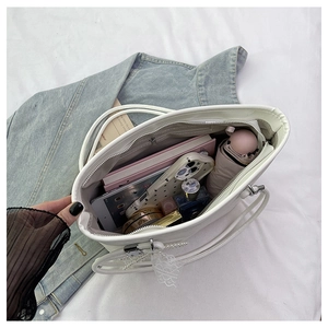 Detailed interior view of a white tote bag showing spacious compartments and zipper closure