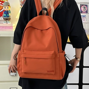 Vista dettagliata dello zaino in nylon arancione con tasca frontale e tasche laterali a coulisse