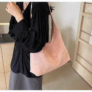 Detailed view of pink tote bag featuring unique pleated texture and glossy finish