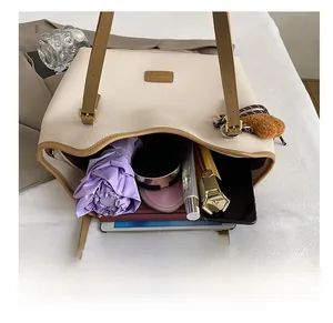 Spacious interior of off-white tote bag showing umbrella, phone, and tablet storage