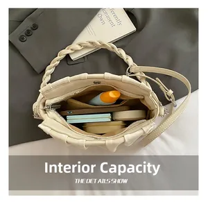 Internal capacity of pleated cream leather underarm bag with chain and woven ring handle