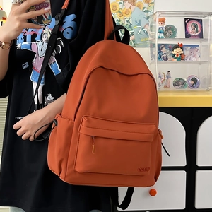 Dettaglio dello zaino in nylon caramello con tasca con zip e coulisse laterale regolabile