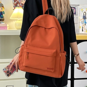 Dettaglio di uno zaino in nylon arancione con tasche laterali e zip frontale esterna