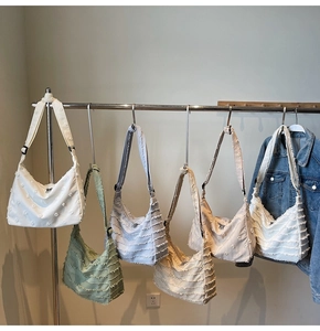 Detailed shot of large canvas tote bags with layered flower fringe in five soft colors