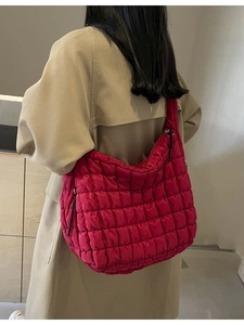 Magenta quilted bubble hobo bag with large capacity shown on a model in trench coat