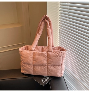Close-up of pink quilted puffer tote bag with soft padded handles and grid stitching details