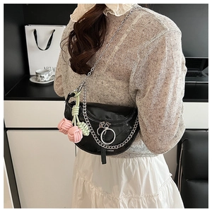 Detail view of black moon bag with silver chain and colorful woven charms on the strap