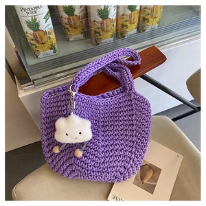 Close-up of purple handmade crochet tote bag with a white plush cloud charm accessory