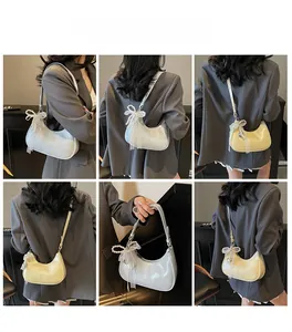Detailansicht der Mondsichel-Tasche mit Glanzeffekt und feiner Spitzenschleife