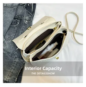 Detail view of the spacious inner compartments of this white woven crossbody bag