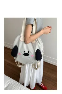 Detail of cream nylon tote bag with cartoon dog embroidery and 3D ears shown on model